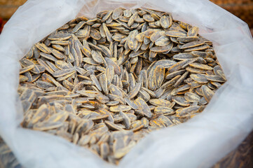 Salty dried sunflower seeds on rolled up sack
