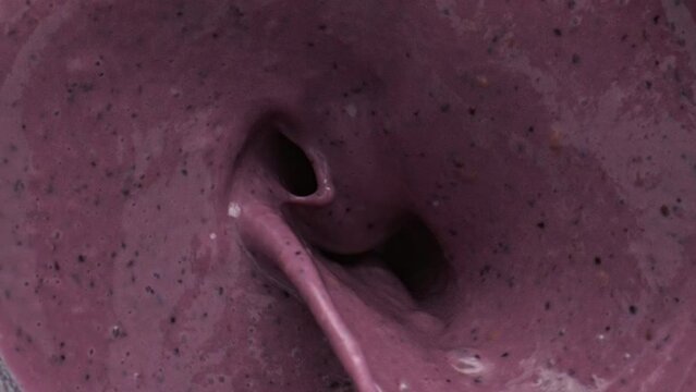 Bananas falling milkshake blender bowl top view. Milk berries smoothie preparing
