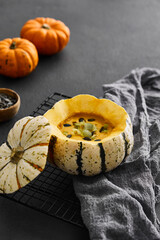 Pumpkin cream soup served in a squash with seeds