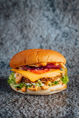 Fresh and juicy double beef cheeseburger with melted cheese on dark textured background