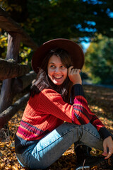 happy woman posing near fence autumn sunny day