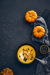 Pumpkin cream soup with croutons on dark background