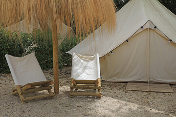 tienda de campaña de loneta blanca con sillones  y sombrilla de paja camping de lujo 4M0A1314-as22