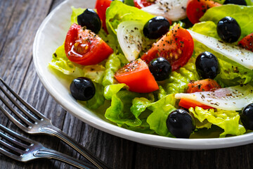 Fresh vegetable salad on wooden table
