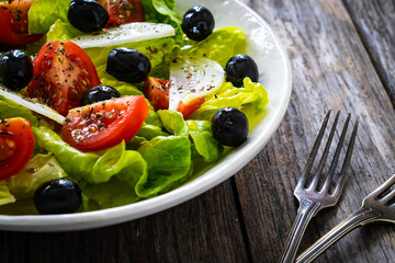 Fresh vegetable salad on wooden table
