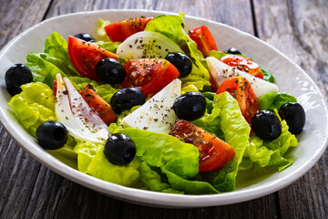 Fresh vegetable salad on wooden table
