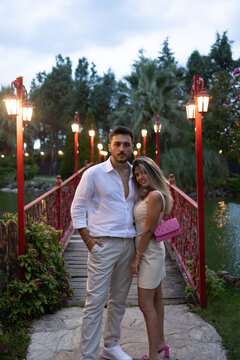 Young couple on romantic date. Kissing on the bridge. Hug each others.