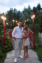 Young couple on romantic date. Kissing on the bridge. Hug each others.