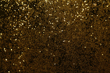 Gold (bronze) glitter shine dots confetti on black. Abstract light blink sparkle backgound.