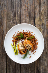 Stuffed meatball with mushrooms, buckwheat groats and pickled cucumbers on wooden table
