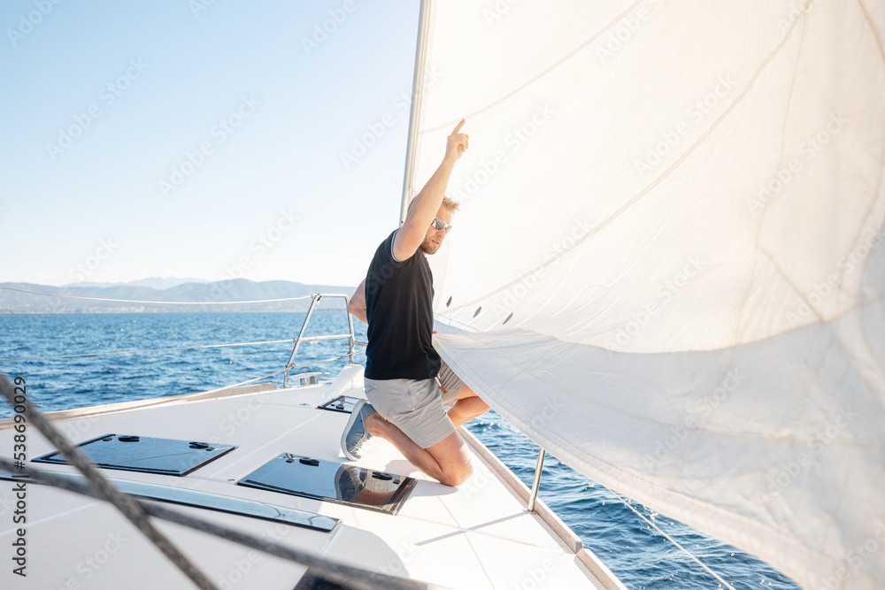 Wall mural man setting sail on his boat or yacht