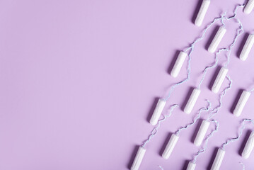 women's tampons a lot lie in a line on a pastel lilac background. flat lay