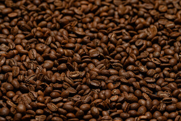 Texture of roasted coffee beans close-up, brown beans.