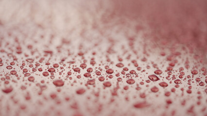 closeup shot of raindrops on red car with hydrophobic coating