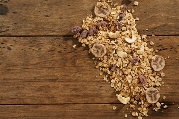 scattered granola with dried fruits on a wooden table
