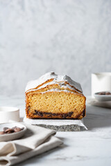 Vanilla cupcake with a sugar crust and a chocolate layer on a marble table, with a copy space on a concrete gray background. Sweet homemade baking.