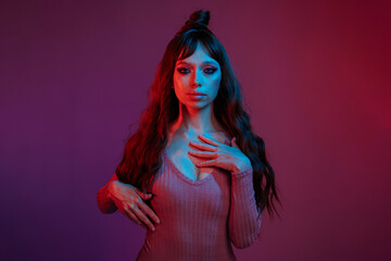 High fashion model in colorful bright neon lights posing at studio