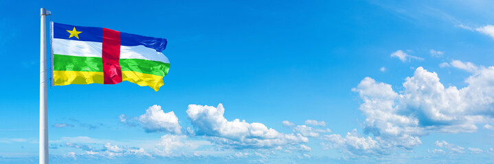 Central African Republic flag waving on a blue sky in beautiful clouds - Horizontal banner
