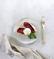 pieces of Cherry strudel with icecream on the plate on light bakground, copy space, top view