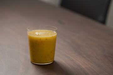 Mango lulo smoothie on walnut wood table with copy space