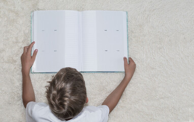 A little boy is looking at an album