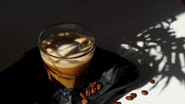 cortado coffee in a glass glass on a stone table with coffee beans. Spanish coffee	