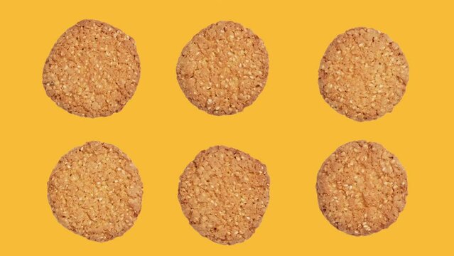 Group of six oatmeal cookies rotating at yellow background. Food concept. Top view of snack. Tasty bakery. Healthy food. 4K, UHD