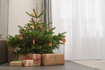 Small christmas tree with natural decorations and gift boxes