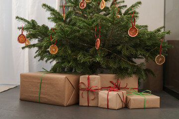 Small christmas tree with natural decorations and gift boxes