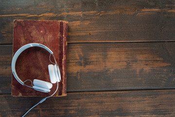 headphones on old book and wooden background