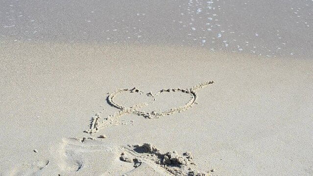 Heart in the sand. Heart pierced by an arrow in the