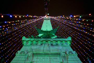 A low angle view of a monument in Indianapolis that is strung with Christmas lights to create a giant Christmas tree.