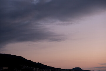 早朝の甲山。太陽が東の空に昇り稜線も徐々に明るくなる。神戸市街地より六甲山系と甲山を望遠レンズで切り取る