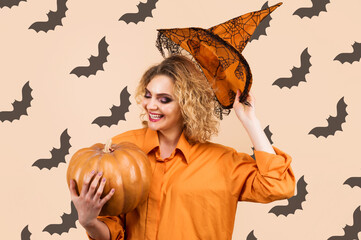 Smiling Witch with Pumpkin. Halloween background. Happy woman in magic hat. Trick or treat.