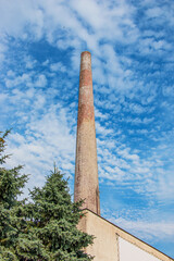 Fototapeta premium The pipe of a gas boiler house against the blue sky. No smoke comes out of the chimney. Energy crisis.
