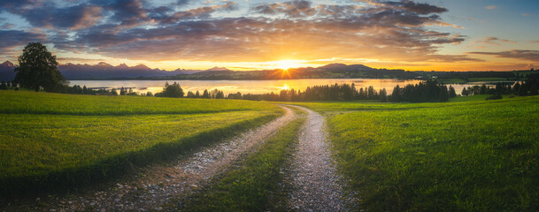 Sunset over the Field, Lake and Mountains with warm colors