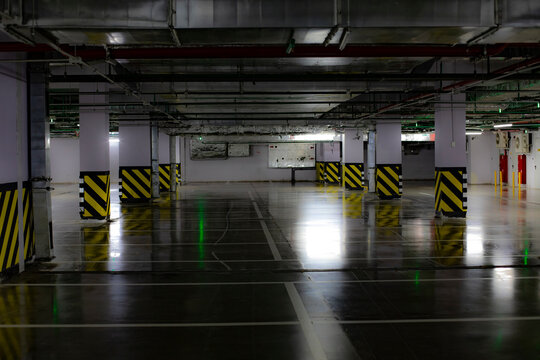 Underground parking, spacious empty space with columns and dim light