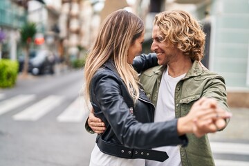 Man and woman couple smiling confident dancing at street