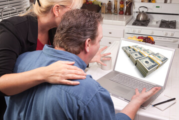 Fototapeta na wymiar Couple In Kitchen Looking at Stacks of Cash Bundles on Their Laptop 