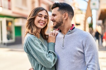 Man and woman smiling confident hugging each other standing at street