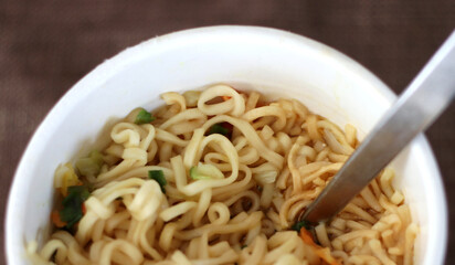 Instant ramen noodles in water service in paper cup ready to eat 