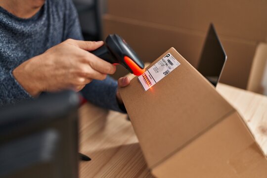 Young hispanic man ecommerce business worker scanning package at office