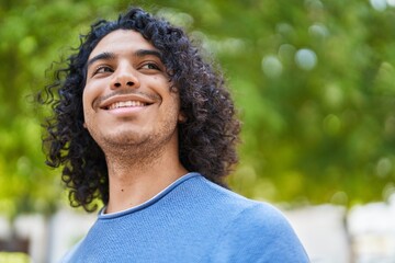 Young latin man smiling confident looking to the sky at park