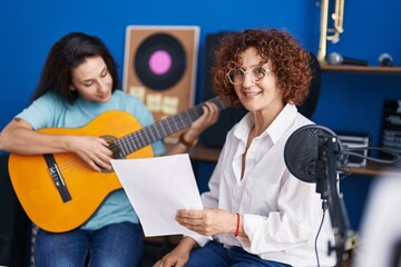 Fototapeta na wymiar Two women musicians having classical guitar lesson at music studio