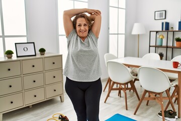 Middle age caucasian woman smiling confident stretching at home