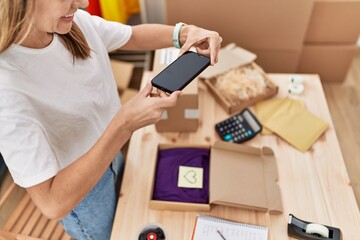 Young hispanic woman smiling confident make photo to clothes order at store