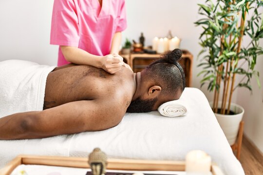 Young african american man having back massage at beauty center