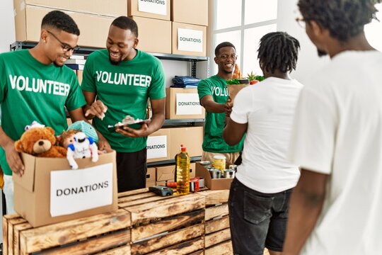 Group Of Young African American Volunteers Helping People At Charity Center.