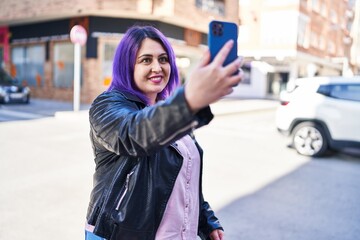 Young beautiful plus size woman smiling confident making selfie by the smartphone at street