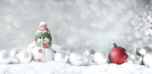 Christmas balls and snowman on snow silver background. Greeting card.